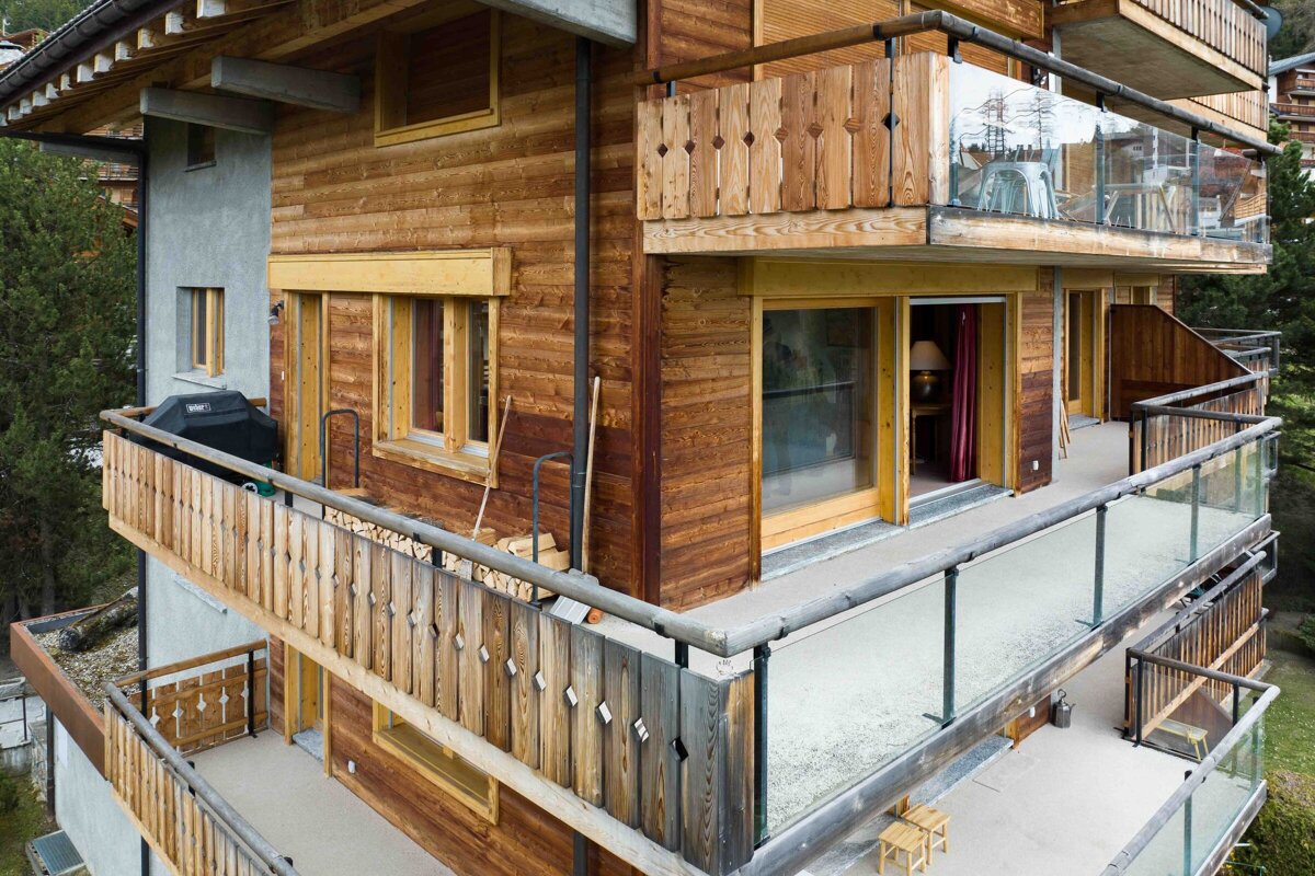 A wooden house with a balcony and a grill