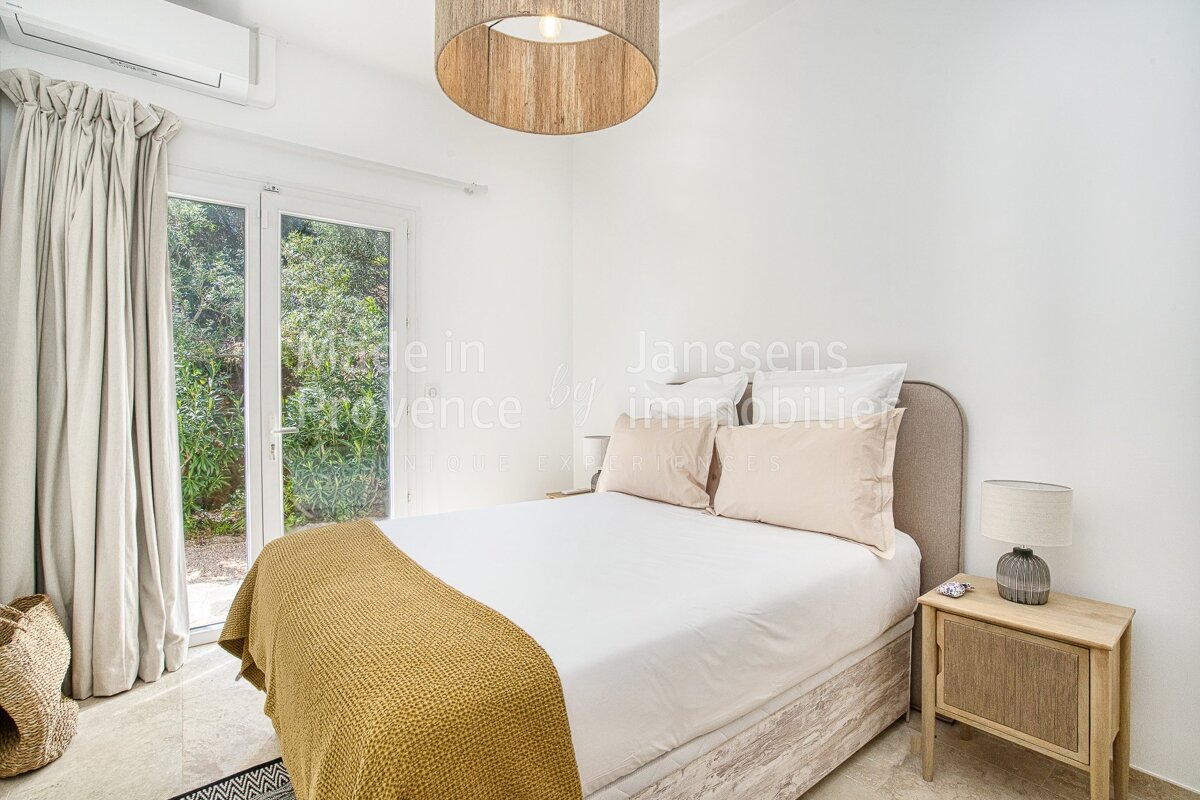 A bedroom with a bed and a nightstand that says made in provence