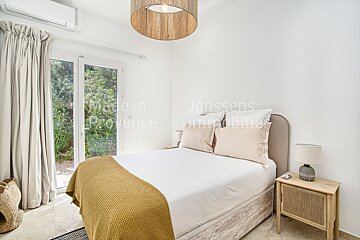 A bedroom with a bed and a nightstand that says made in provence