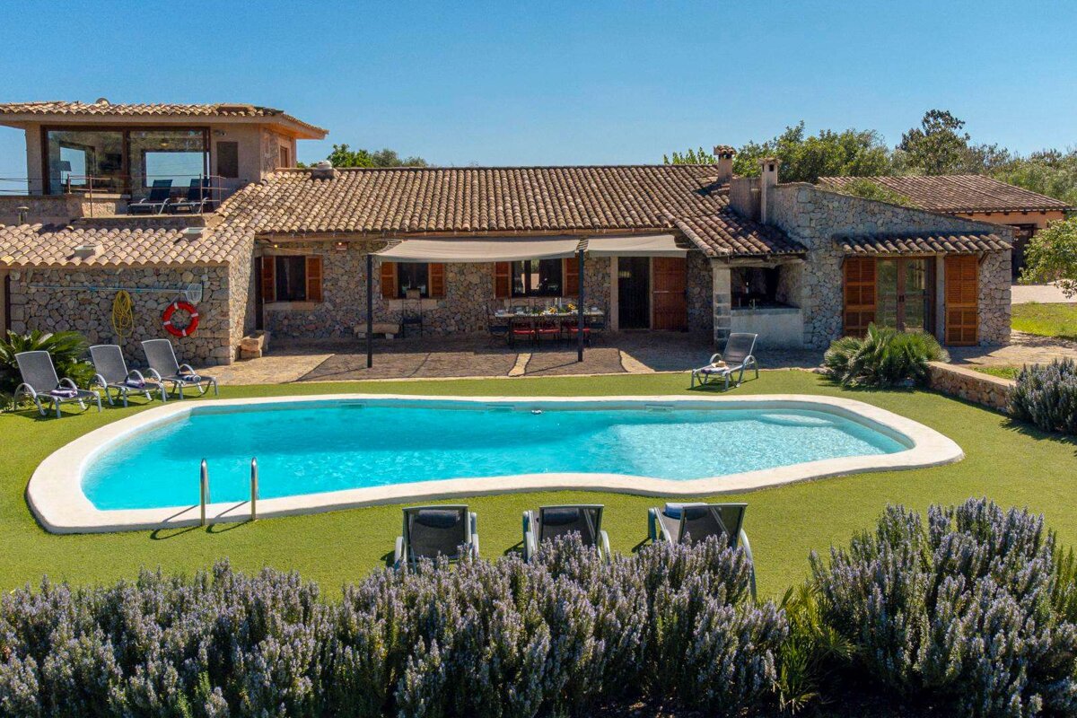 A large house with a large swimming pool in front of it