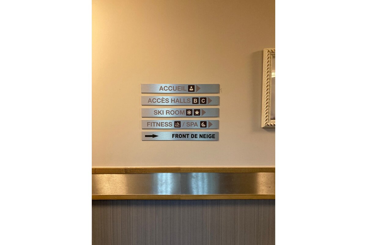 A sign on a wall points to a ski room