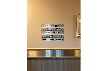 A sign on a wall points to a ski room