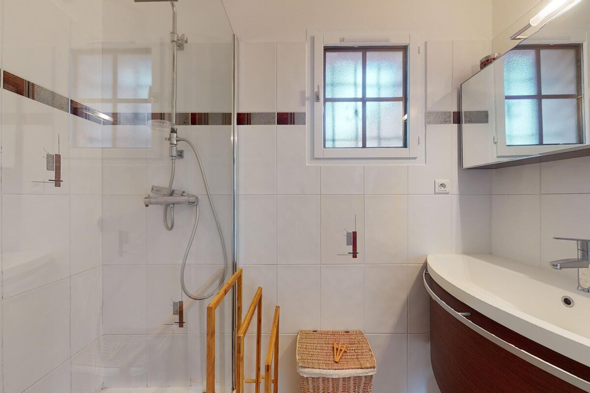 A bathroom with a sink and a shower with a window