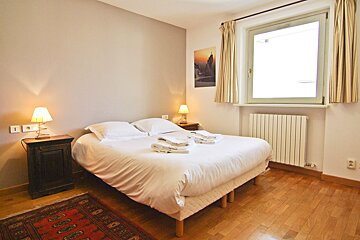 A bedroom with a bed and a picture on the wall