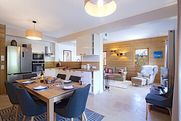 A dining room table with a bottle of wine on it