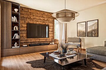 A stylish living room features a prominent wooden plank accent wall with a large TV, sleek cabinetry, and a central coffee table. A textured pendant light hangs above.