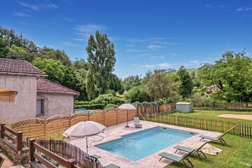 A large swimming pool surrounded by chairs and umbrellas