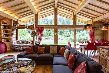 A living room with a large sectional couch and a table