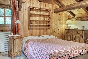 A bedroom with a bed and a dresser that says mountain base