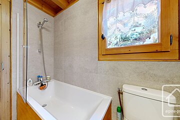 A bathroom with a bathtub and a toilet and the word alpine on the bottom