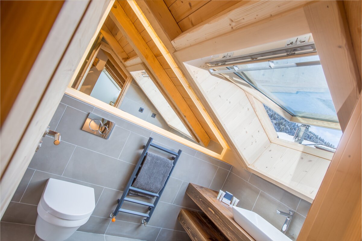 A bathroom with a toilet a sink and a skylight
