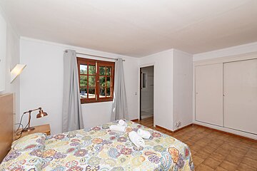 A bedroom with a large bed and a window