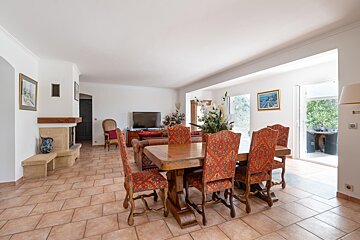 A living room with a table and chairs and a television