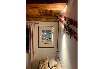 A framed picture of skis hangs on a wall next to a bed