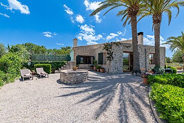 A stone house with palm trees in front of it
