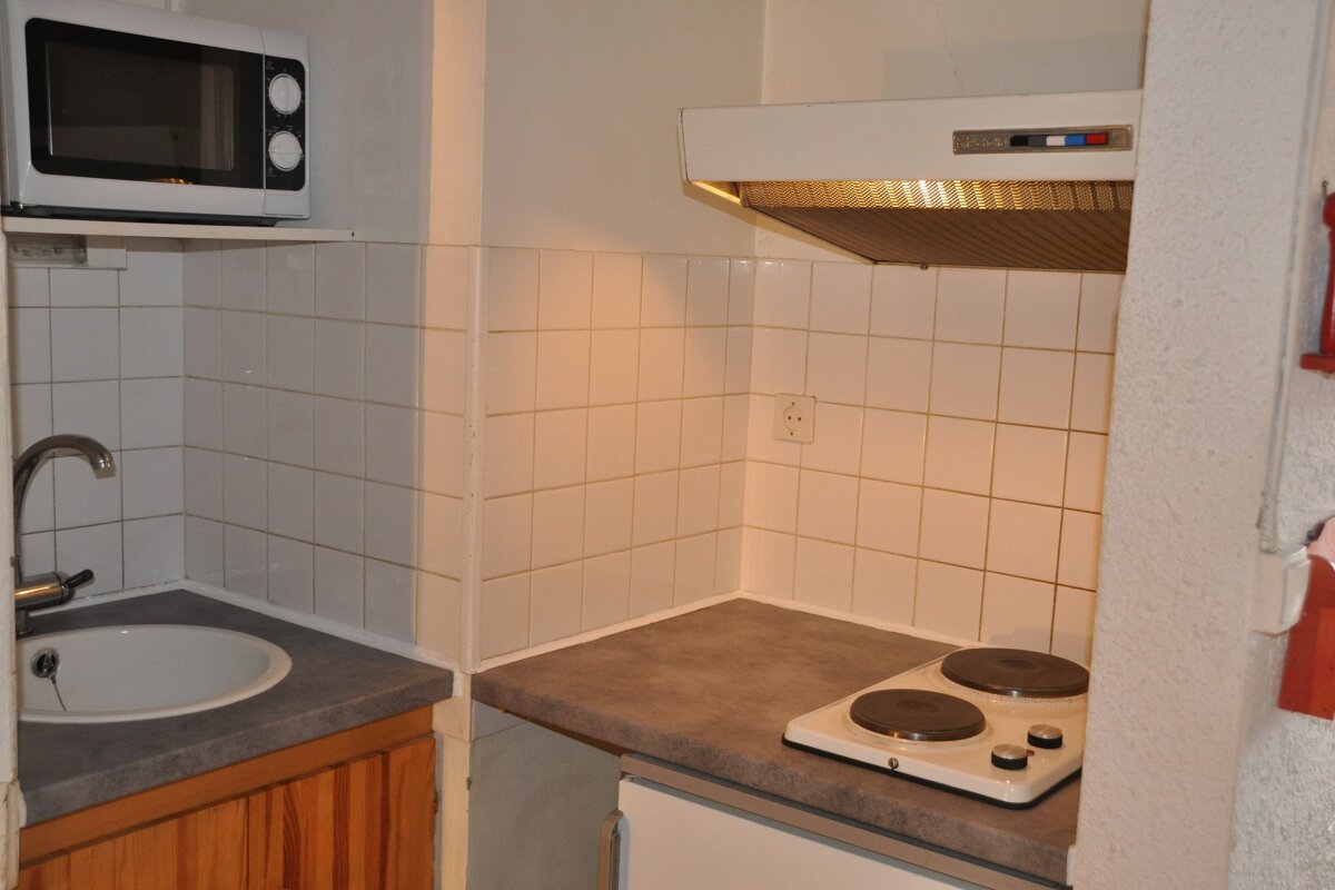 A small kitchen with a stove top oven and a microwave
