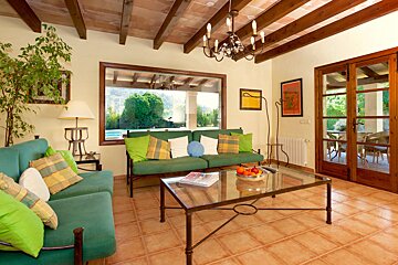 A living room with a green couch and a glass coffee table