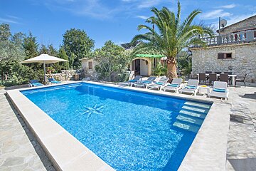 A large swimming pool with chairs and umbrellas around it