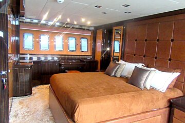 A bedroom with a large bed and a smoke detector on the ceiling