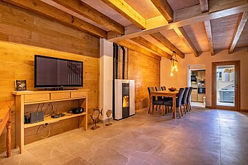 A living room with a table and chairs and a flat screen tv