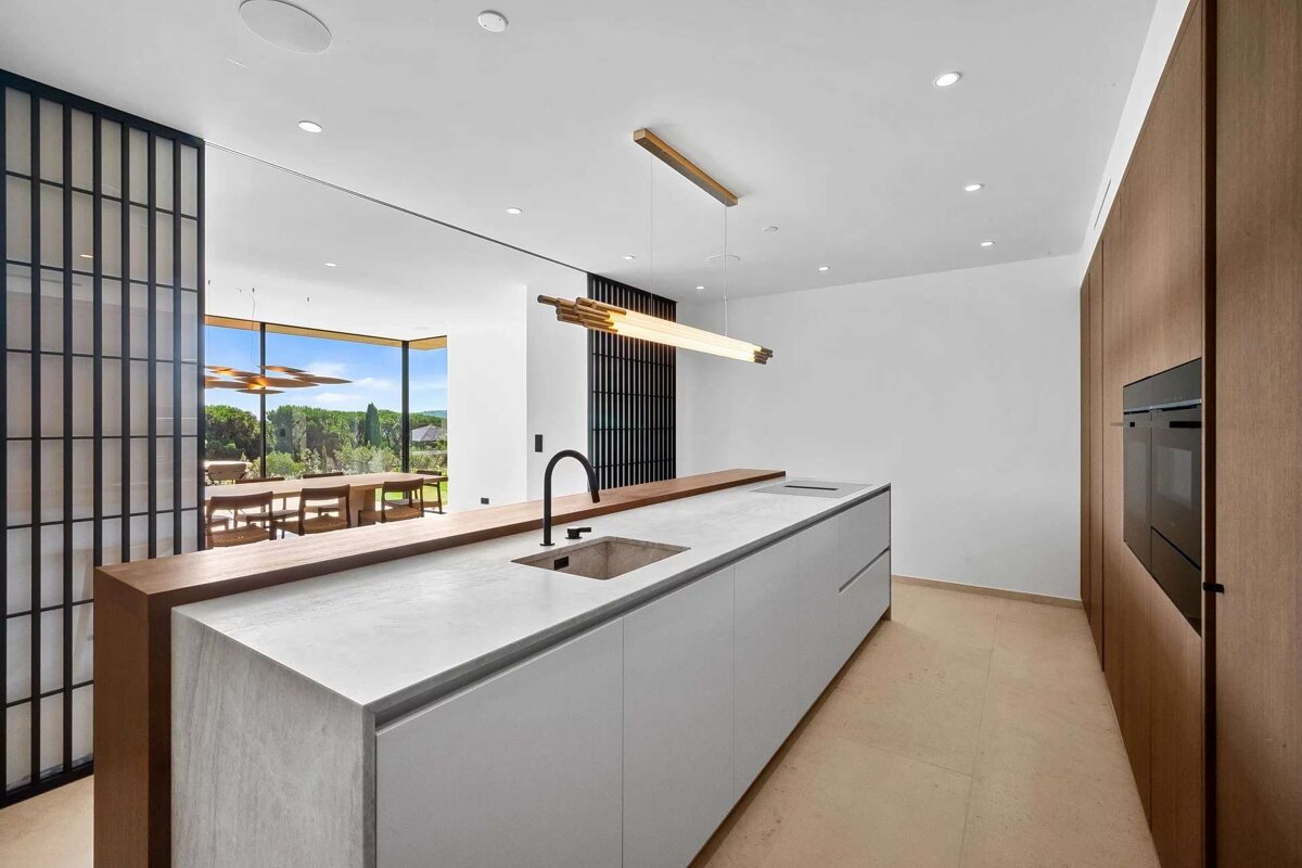 A kitchen with white cabinets and a stainless steel sink