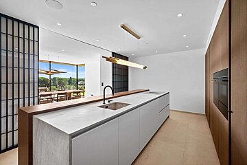 A kitchen with white cabinets and a stainless steel sink