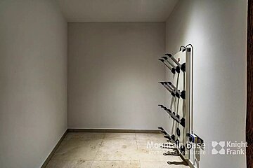 An empty room with a knight frank logo on the wall