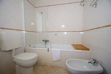 A bathroom with a toilet a sink and a bathtub