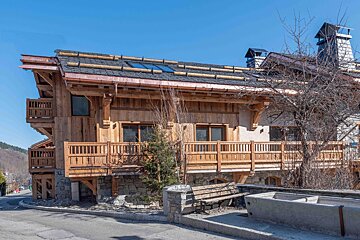 A large wooden house with a copper roof