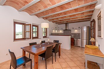 A dining room with a table and chairs and a refrigerator