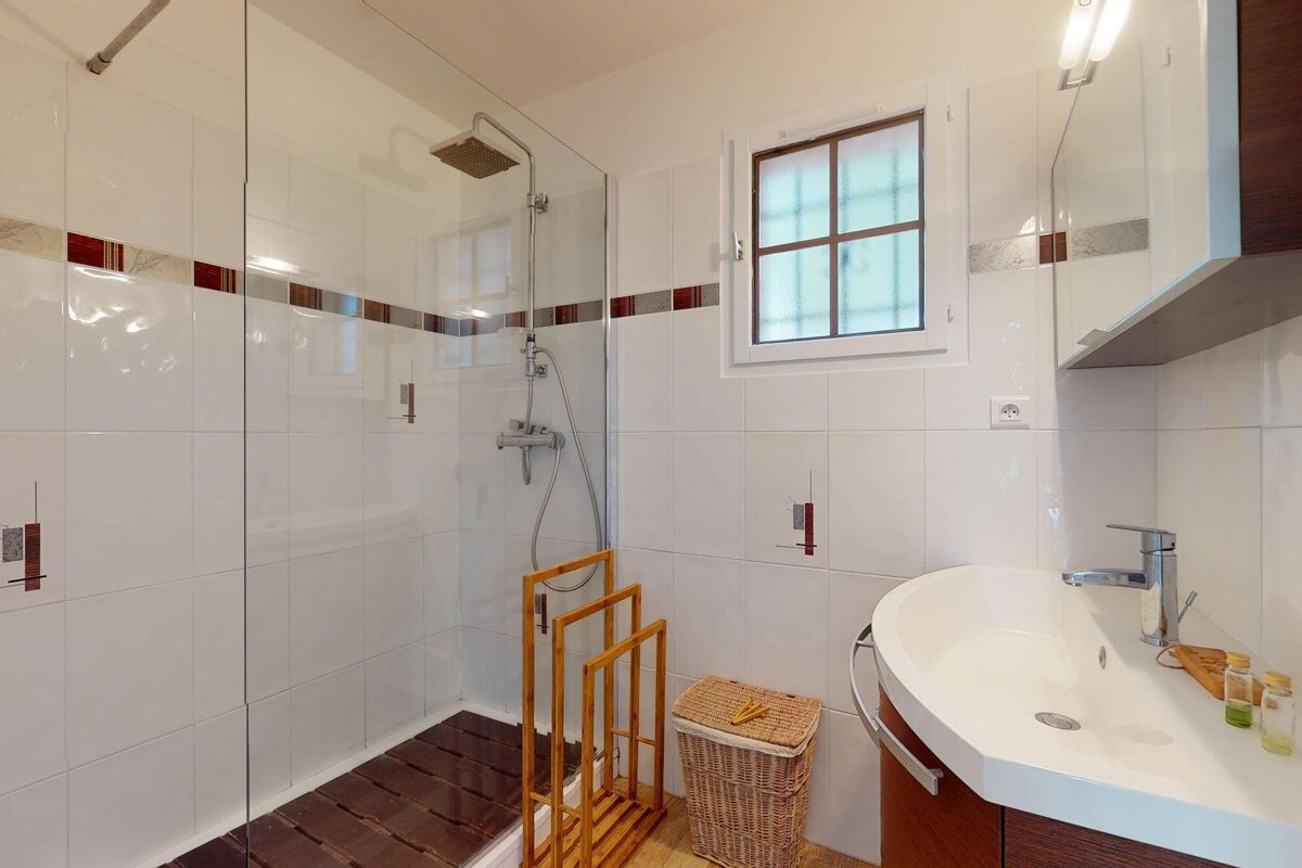 A bathroom with a sink and a walk in shower