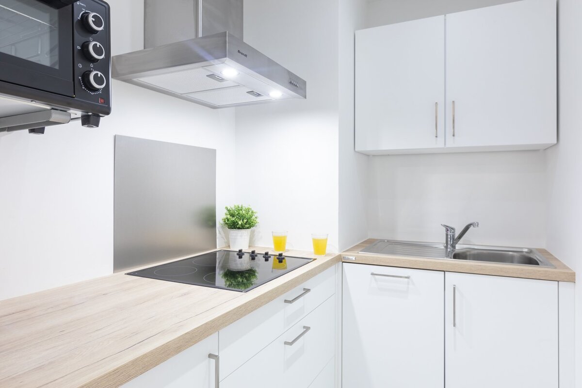 A kitchen with a stove top oven and a sink