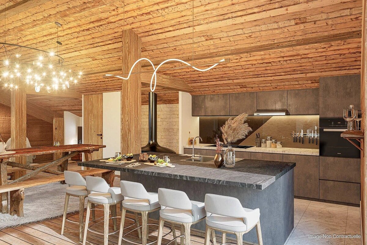 A cozy, modern chalet kitchen and dining area. Features a wooden beamed ceiling, sleek grey kitchen with an island, bar stools, and a rustic dining table.