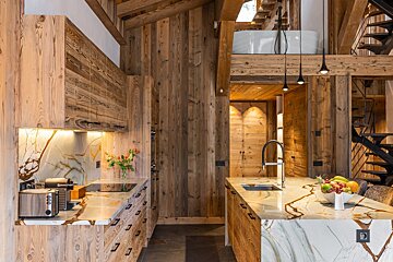A kitchen with wooden cabinets and marble counter tops