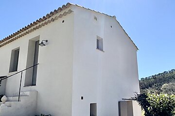A white building with a staircase leading up to it