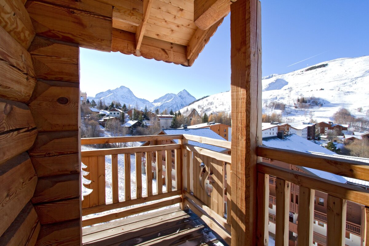 A balcony with a view of a snowy mountain range
