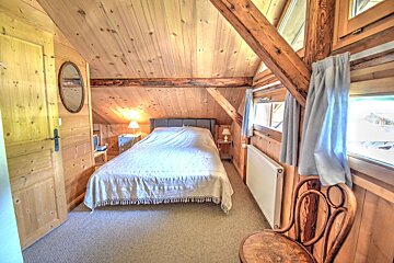 A bedroom with a bed and a chair in it