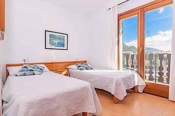 A bedroom with two beds and a picture on the wall