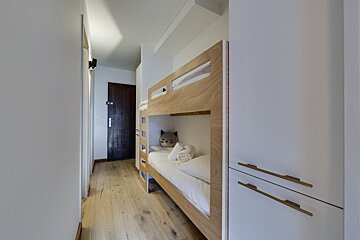 A bunk bed with a cat pillow on top of it