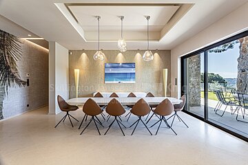A dining room with a table and chairs and a painting on the wall