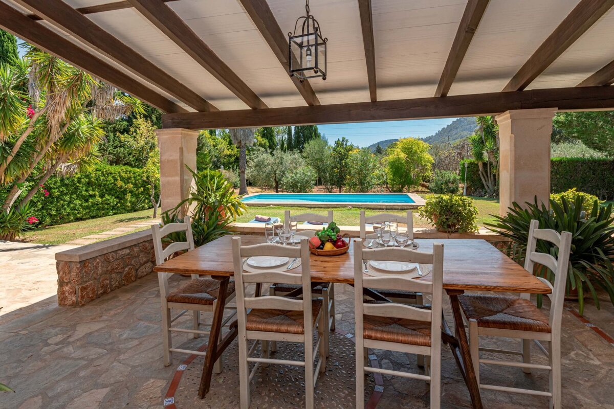 A table and chairs on a patio overlooking a pool