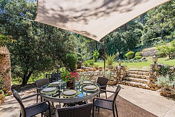 A patio with a table and chairs under an umbrella