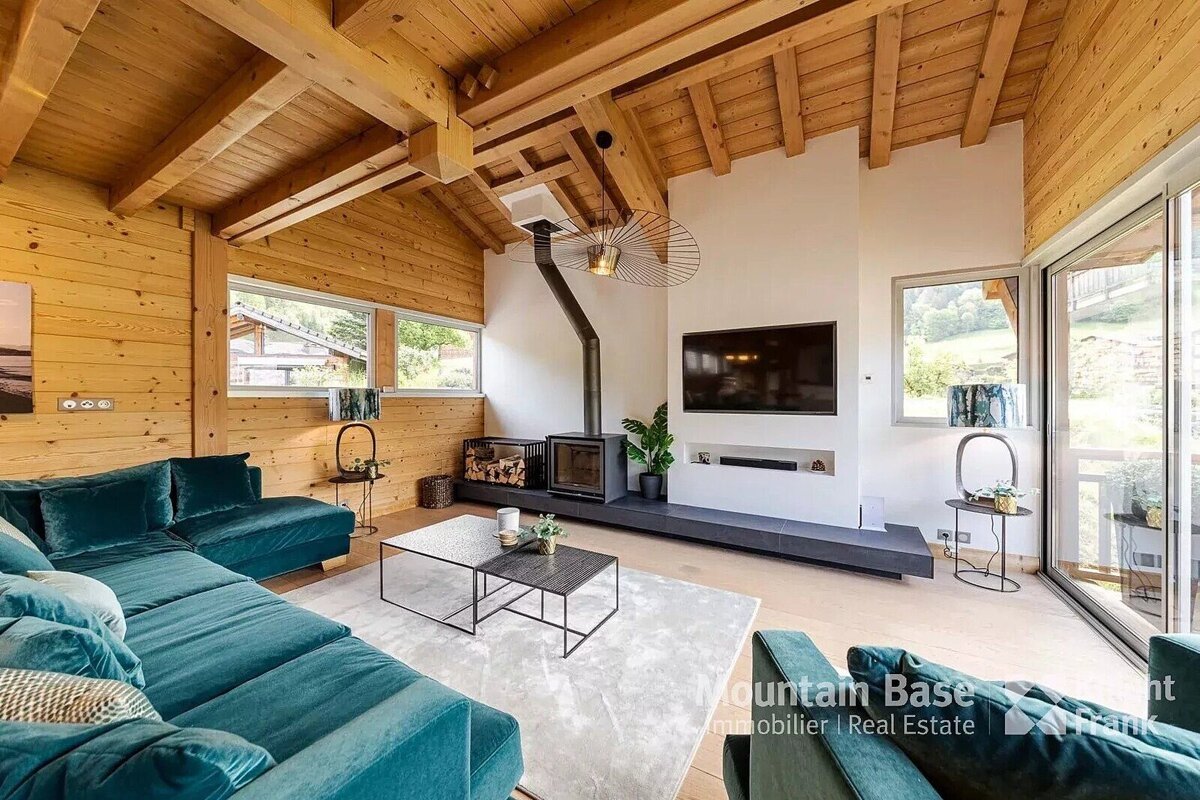 A living room with a blue couch and a mountain base real estate logo