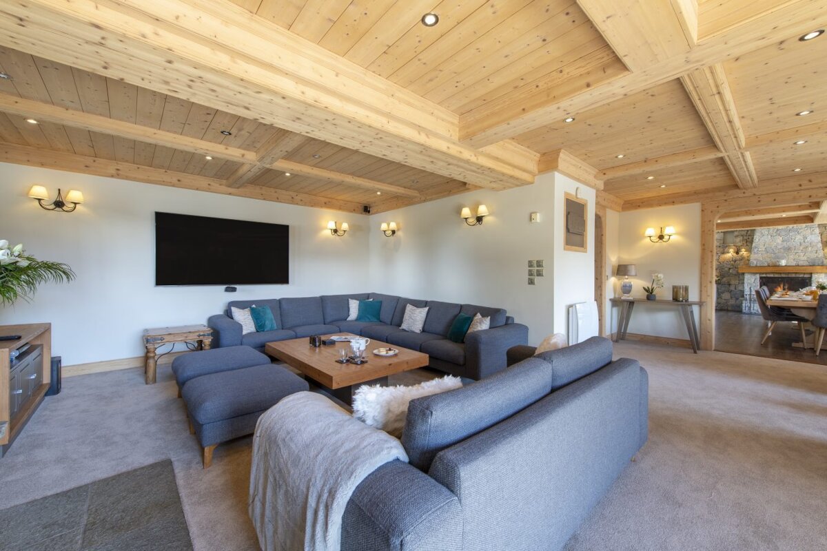 A living room with a large sectional couch and a flat screen tv