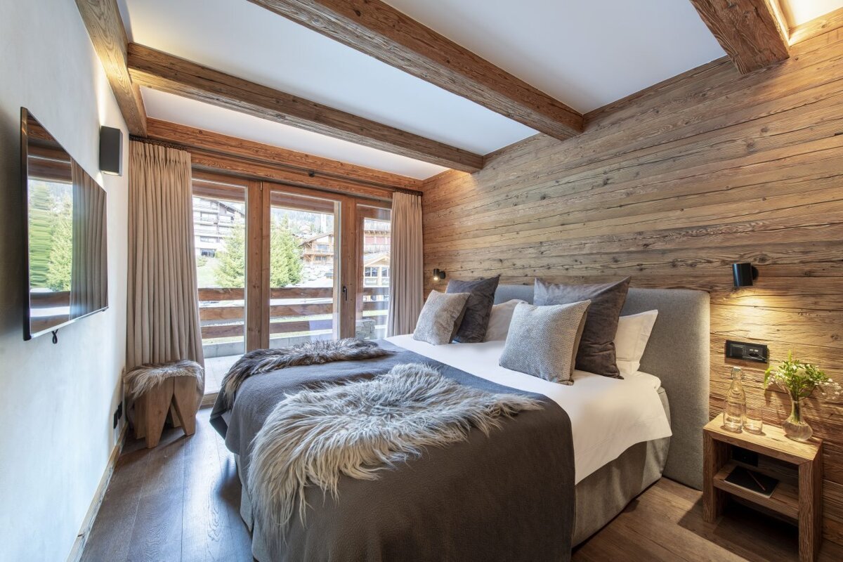 A bedroom with two beds and a flat screen tv