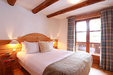A bedroom with a wooden headboard and a bed