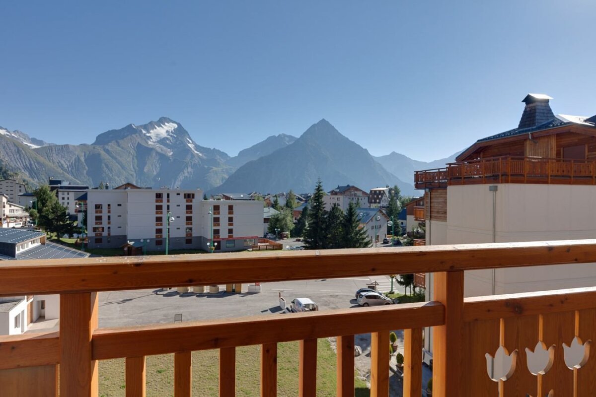 A balcony overlooking a city with mountains in the background