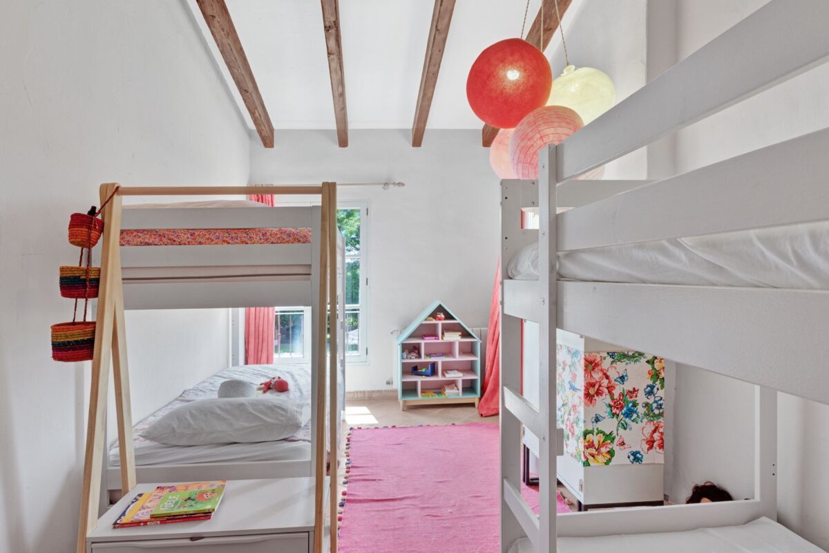 A bedroom with bunk beds and a book on a nightstand