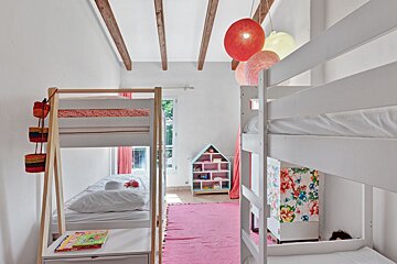 A bedroom with bunk beds and a book on a nightstand