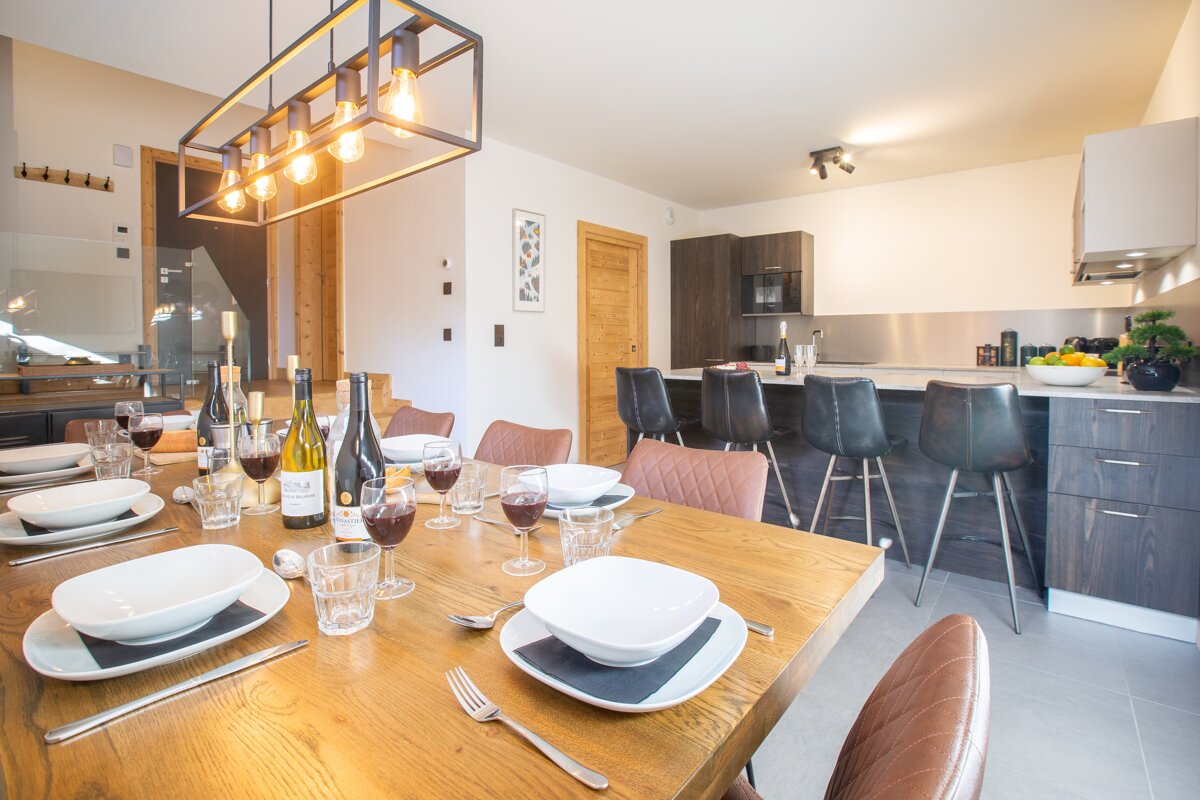 A dining room table with a bottle of wine on it